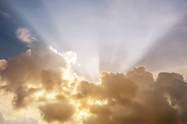 Bulutların arasından, gün batımı parlayan ışık ışınları