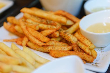 Beyaz bir kase baharatlı patates kızartması