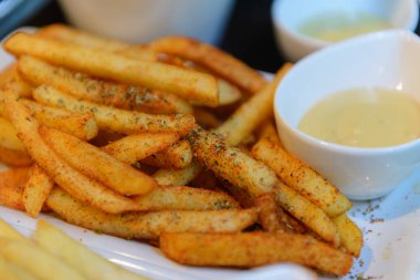 Beyaz bir kase baharatlı patates kızartması
