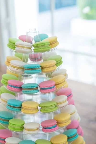 Colorful macarons on pyramid-shaped plastic stand at party — Stock Photo, Image