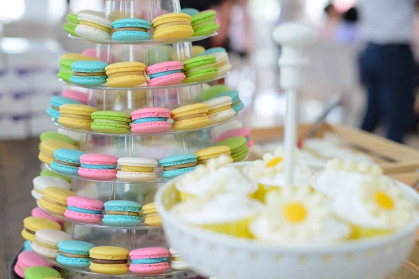 Colorful macarons on pyramid-shaped plastic stand at party — Stock Photo, Image