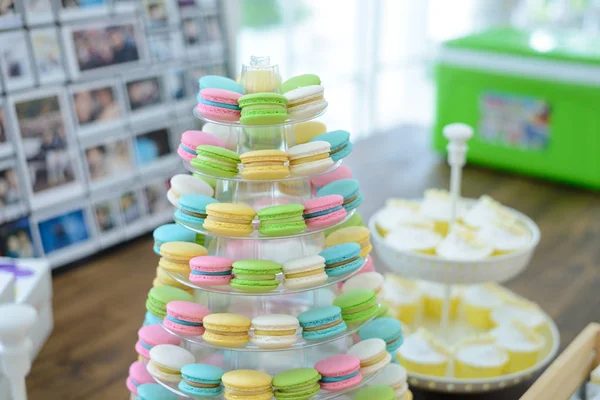 Colorful macarons on pyramid-shaped plastic stand at party — Stock Photo, Image