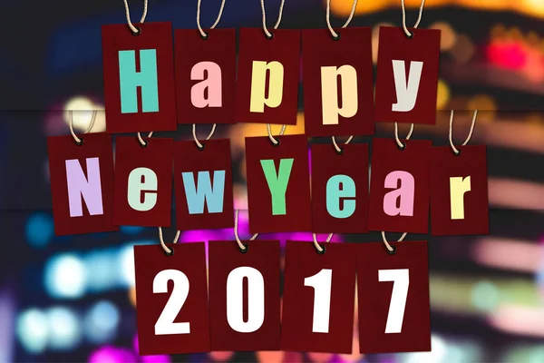 Gelukkig Nieuwjaar 2017. alfabet Word op rood papier tags op bokeh lichten — Stockfoto