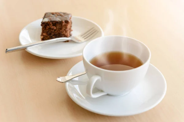 나무 테이블에 브라 우 니와 함께 뜨거운 차 한잔 — 스톡 사진