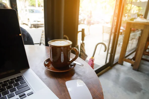 Kahve fincanı ve kafede ahşap masa üstünde laptop. iş c — Stok fotoğraf