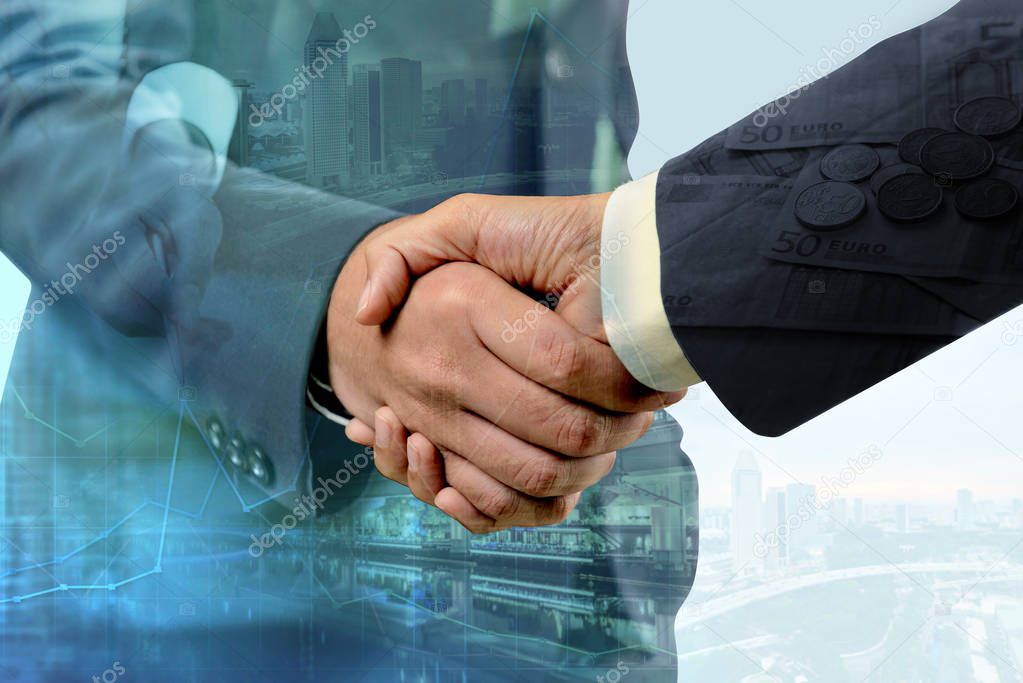 Double exposure of handshake between businessman with cityscape 