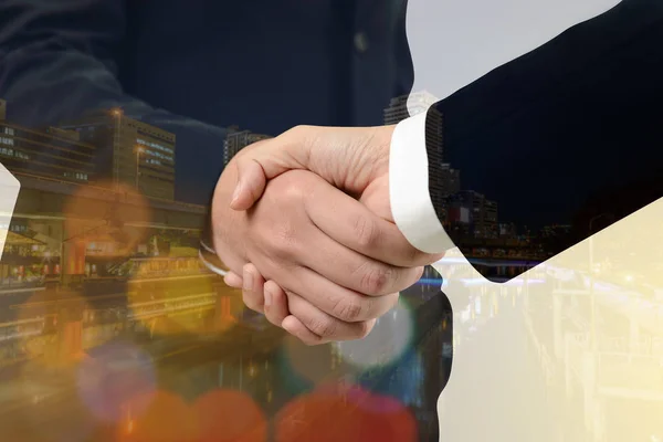 Double exposure of handshake between businessman with cityscape — Stock Photo, Image