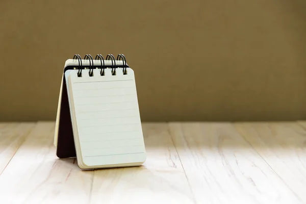 Maquette papier carnet de notes (bloc-notes) debout sur une table en bois pour écrire une information avec espace de copie — Photo