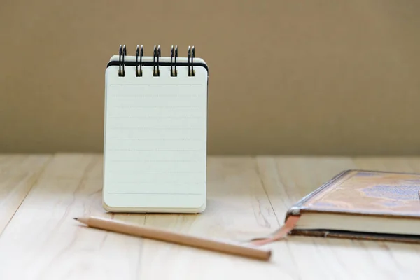 Küçük not kitap kağıdı (Not Defteri) ayakta bilgi ile kalem ve ahşap masa kitap yazmak için — Stok fotoğraf