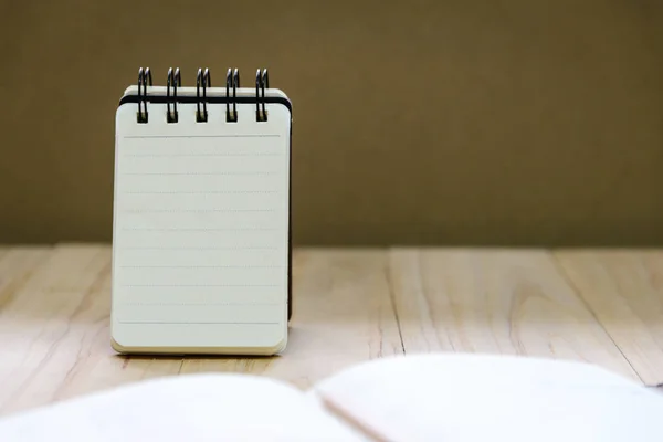 Papier pour carnet de notes (bloc-notes) pour écrire des informations avec crayon et livre sur table en bois — Photo