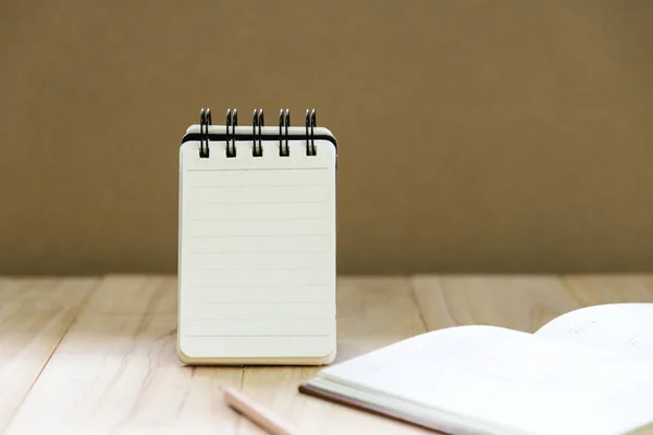 Papier pour carnet de notes (bloc-notes) pour écrire des informations avec crayon et livre sur table en bois — Photo