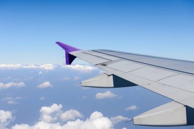 Uçak bulutların üzerinde uçan kanat. Bir uçağın penceresinden görüntülemek