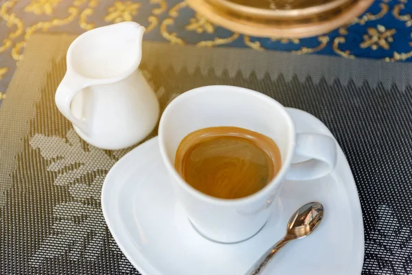 Tasse heißen Kaffee und Milch auf dem Tisch. — Stockfoto