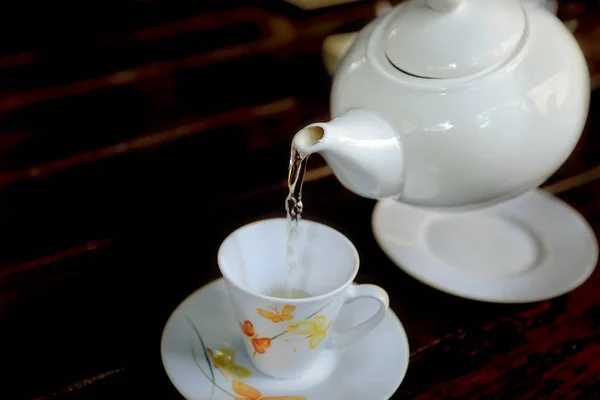 Temps de pause thé. Le thé est versé de la théière dans une tasse . — Photo