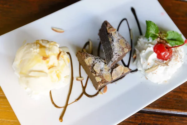 Шоколадный пирог с ванильным мороженым и взбитым сливками — стоковое фото
