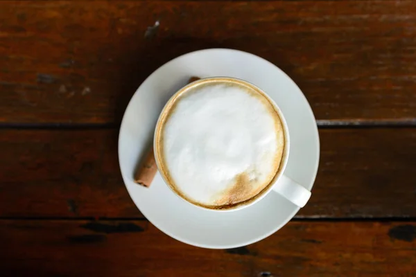 Vista dall'alto della tazza di cappuccino caldo con schiuma di latte su tabe di legno — Foto Stock