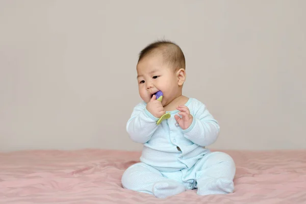 Porträtt av asiatiska pojke lilla 7 månader gamla. bära en mössa på sängen i sitt rum — Stockfoto