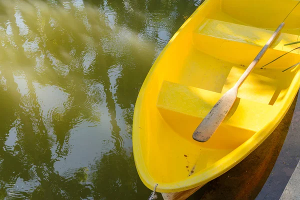 Remo de madeira no barco a remos de fibra amarela na lagoa — Fotografia de Stock