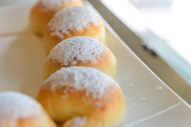 Ev yapımı taze ekmek ile beyaz plaka üstüne pudra şekeri