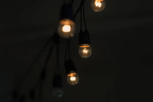 Lampadina retrò appesa con sfondo spazio scuro per la vostra decorazione, concetto di creatività — Foto Stock