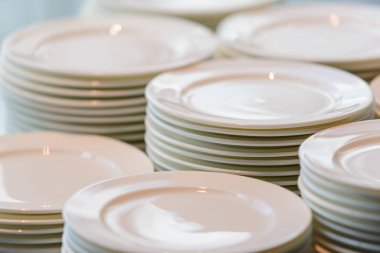 Restoranda yemek büfesi için temizlenmiş beyaz tabak yığınları