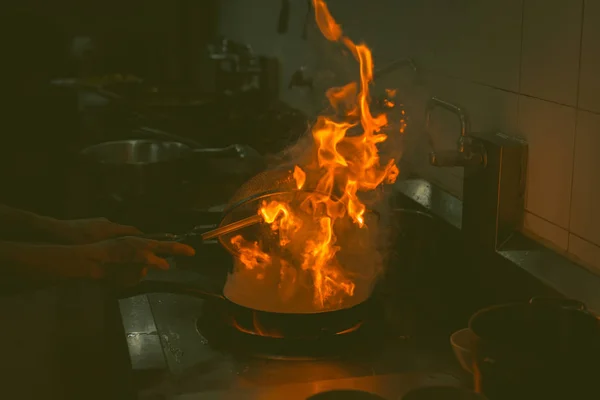 シェフの料理とレストランのキッチンで食べ物に炎を行う — ストック写真