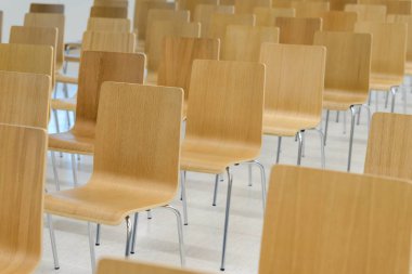 Birçok boş ahşap sandalyeler toplantı odasında düzgün satırları ayarla