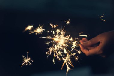 Maytap gece arka plan ile tutan eller