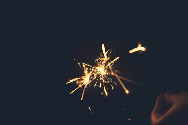 夜背景で線香花火を保持している女性の手 — ストック写真