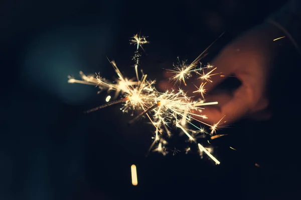 Mãos femininas segurando sparkler com fundo noturno — Fotografia de Stock