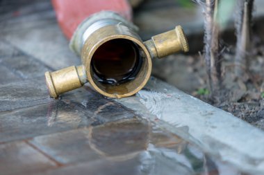 Yangın hortumu kullanımdan sonra sert zeminde su yansıması ile dışarı su akar