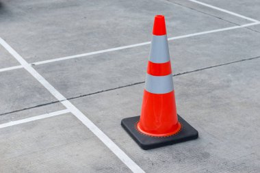 Beton zemin üzerinde Turuncu trafik konisi beyaz ışık yansıtıcı şerit. yol işareti