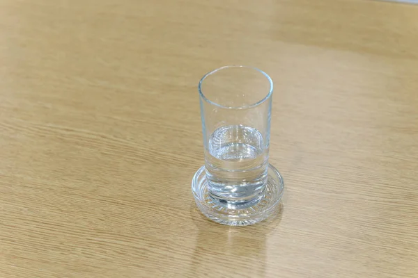 Vaso de agua sobre mesa de madera con espacio para copiar. Enfoque selectivo — Foto de Stock
