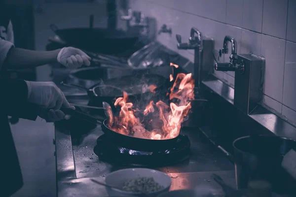 Chef cozinhar e fazer flambe em alimentos na cozinha do restaurante — Fotografia de Stock