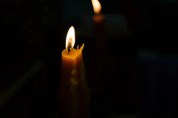 Vela amarela queimando brilhantemente em fundo preto — Fotografia de Stock