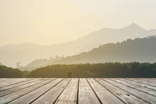 Terrasse en bois vide avec des couches de silhouettes de crêtes de montagne sur fond — Photo