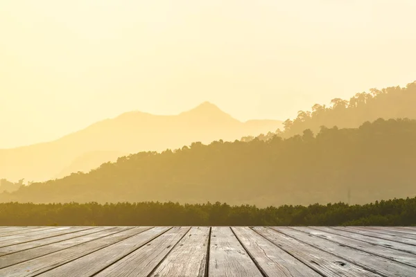 Terrasse en bois vide avec des couches de silhouettes de crêtes de montagne sur fond — Photo