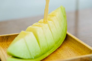 Ahşap tabak, seçici odak taze tatlı yeşil kavun.