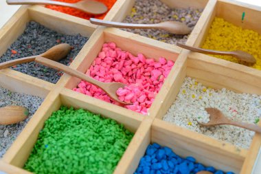 Ağaç sanat tahta kova kutusunda tahta kaşıkla renkli çakıl taşları