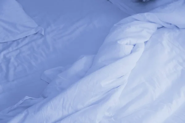 Bovenaanzicht van verfrommeld deken op slordig bed na wakker worden. Blauw aan — Stockfoto