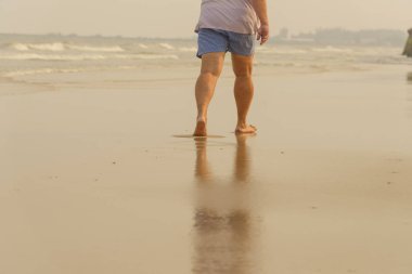 Yalnız kumsalda yürüyen adam. plaj seyahat etmek yaz saati kavramı