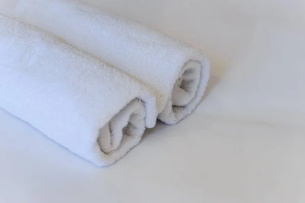 침대보에 놓여 있는 하얀 수건 — 스톡 사진