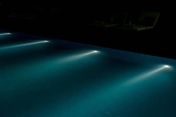Osvětlovací zařízení pod vodou v bazénu v noci — Stock fotografie