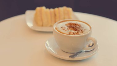 Sabahları kahvaltıda bir fincan sıcak kapuçino ve sandviç.