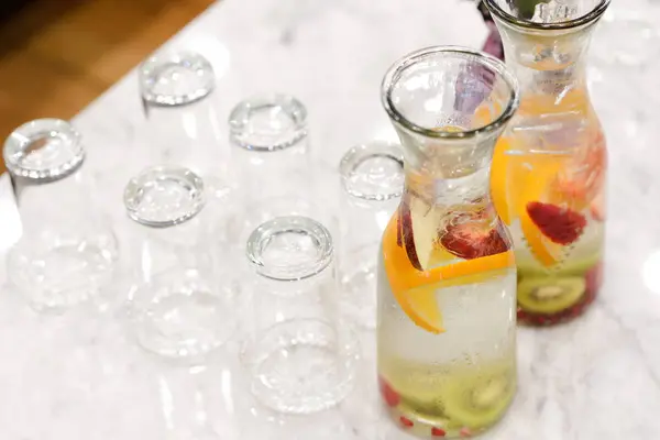 Aufgossenes Entgiftungswasser. Fruchtaufgossenes aromatisiertes Wasser, Orangenscheibe, Apfel- und Kiwi-Scheibe im Glas mit Glas. — Stockfoto