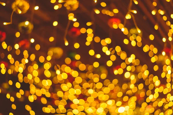 Defokussierte Lichter von Weihnachtsschmuck hängen von der Decke. ligths Bokeh-Design für Hintergrund. noel. frohes neues Jahr. — Stockfoto