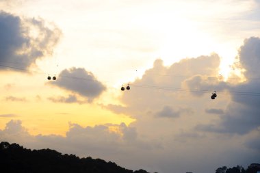 Singapur silueti. Teleferikle Sentosa Adası 'na akşam ulaşımı.