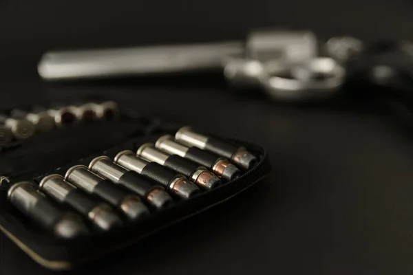 357 Caliber hollow point bullets near revolver pistol gun on black background