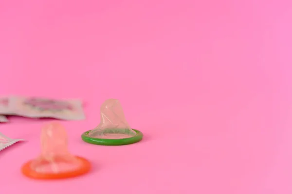 两个打开避孕套 避孕套包在粉红色的纸张背景上 并有复制的文字空间 生殖健康 避孕和安全性行为概念 — 图库照片