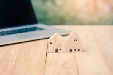 Ahşap masada dizüstü bilgisayarı olan ev modeli. kredi gayrimenkul veya emlak kredisi yatırım kavramı